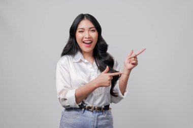 Beyaz gömlekli neşeli genç Asyalı kadın yanındaki fotokopi odasını işaret ediyor, beyaz arka planla izole edilmiş..