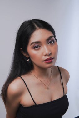 Makyajlı, mor göz farı ve kırmızı dudaklı güzel Asyalı kadın kameraya poz veriyor. Güzellik konsepti.