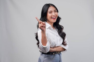 Beyaz gömlekli neşeli genç Asyalı kadın beyaz arka planla izole edilmiş fotokopi odasını işaret ediyor..