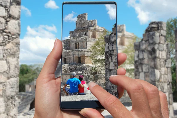 Taking photo by mobile phone couple relax in Mexican pyramid.