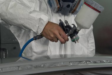 Boya tabancası ile ressam bölümü arabada spreyler.