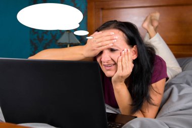 Yatağında bilgisayar olan baloncuk fikirli bir kadınla komik bir resim..