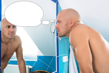 Kabarcık fikirli komik bir adam banyodaki aynaya bakıyor..