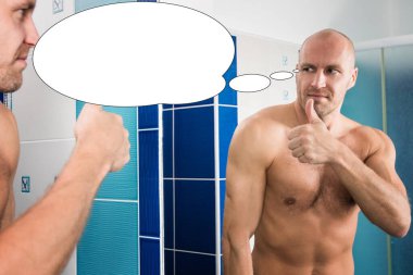 Kabarcık fikirli adam banyodaki aynada kaslarına bakıyor..