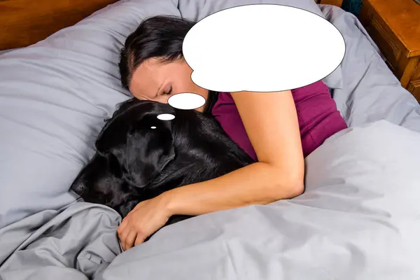 Funny picture with bubble idea woman sleeping in bed with dog.
