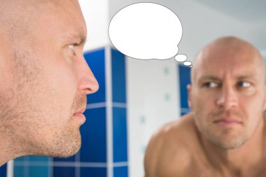 Kabarcık fikirli komik bir adam banyodaki aynaya bakıyor..