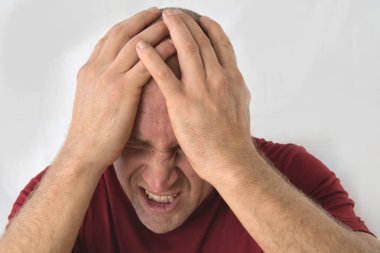 Stresli bir adamın ellerini kafasına bastırması, baş ağrısı..