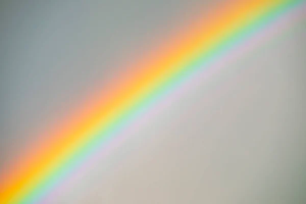 Close-up of vibrant, bright rainbow on the sky. Rainbow texture.