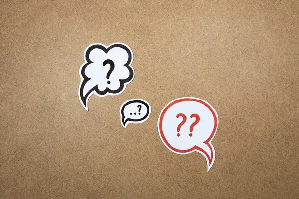 Question marks in speech bubbles. Paper shape of bubble with hand drawn interrogation points. Question concept, important information, dispute, hesitation concept.