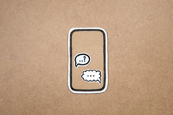 Mobile phone made our of paper with speech bubbles on the display, concept of chatting with smartphone. Cardboard phone with chat application, massages, sms. Modern communication concept.