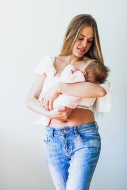 Happy young beautiful mather with smiling baby in her arms.