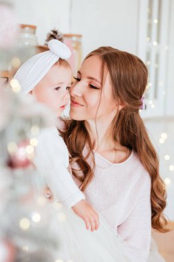 Yeni yıl. Anne ve kızı açık pembe gözlüklerle mutfakta Noel süslemeleri yapıyorlar. Giysiler, kalın kazaklar. Yeni yıl konsepti. Yüksek kalite fotoğraf