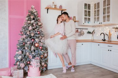 Yeni yıl. Mutfakta açık pembe Noel süsleriyle geçen bir aşk hikayesi. Giysiler, kalın kazaklar. Yeni yıl konsepti. Yaşam tarzı. Yüksek kalite fotoğraf