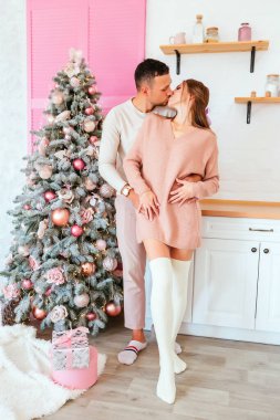 Yeni yıl. Mutfakta açık pembe Noel süsleriyle geçen bir aşk hikayesi. Giysiler, kalın kazaklar. Yeni yıl konsepti. Yaşam tarzı. Yüksek kalite fotoğraf