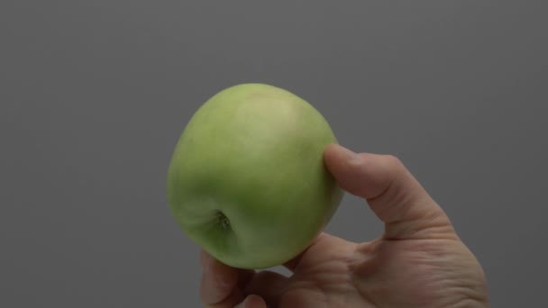 Semerenkos Elması Gri Bir Arka Planda Elinde Döner — Stok video