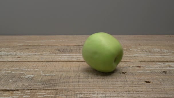 Gri Bir Arka Planda Tahta Bir Zeminde Yeşil Bir Elma — Stok video