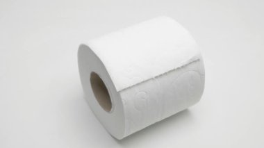 Bir rulo tuvalet kağıdı beyaz arka planda döner. Video.