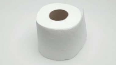 Bir rulo tuvalet kağıdı beyaz arka planda döner. Video.