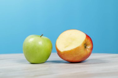 Masada farklı türde elmalar var. Mavi arka plan. Yakın plan..