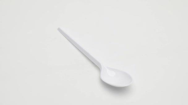 塑料一次性勺子在白色背景上旋转 被隔离了 — 图库视频影像