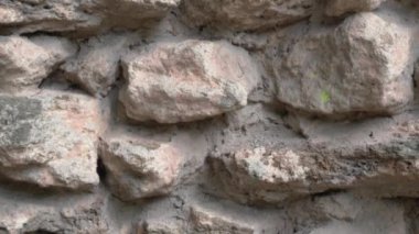 Eskimiş, dokulu taş bir duvarın sanatsal açıdan yakın çekimi, yıpranmış görünüşünü ve doğal cazibesini güzel bir şekilde gözler önüne seriyor.