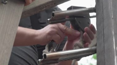 Kırsal bir zemine karşı açık hava ekipmanları üzerinde gayretli bir şekilde çalışan ellerin yakın çekimi