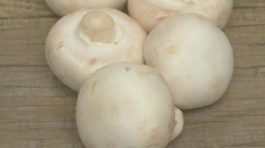 Kırsal ahşap arka planda zarif bir şekilde yerleştirilmiş taze toplanmış beyaz mantar kümesi.