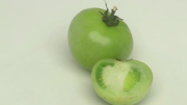 Taze, canlı yeşil bir domates, özenle dilimlenmiş. İçi sulu, çeşitli tarifler için mükemmel.