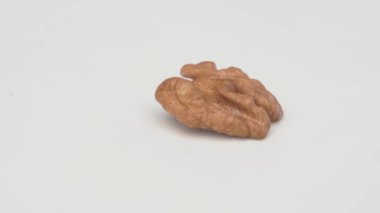 Tek bir ceviz zarif bir şekilde eşsiz şeklini ve farklı dokusunu el değmemiş beyaz arka planda sergiliyor.