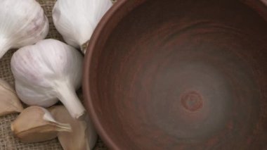 Renkli bir biber dizisi ve çuval bezinde taze sarımsak. Yemek temaları ve lezzetli tarifler için mükemmel.