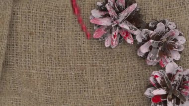 Çuval beziyle süslenmiş kozalaklı kırmızı tatil süslemeleri harika bir şenlik tarzı yaratır.