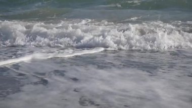 Dalgalar sakin, güzel bir plaja nazikçe çarpar. Doğanın dingin özünü ve sakinliğini canlı bir şekilde yakalar.