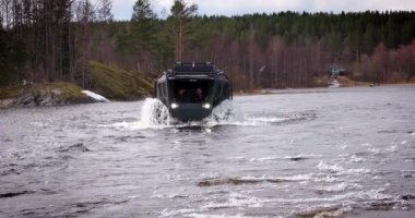 Karelia Cumhuriyeti, RUSSIA - 09 Mayıs 2023: Sherp arazi aracı gölde yüzüyor ve off-road kullanıyor.