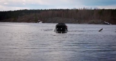 Karelia Cumhuriyeti, RUSSIA - 09 Mayıs 2023: Sherp arazi aracı gölde yüzüyor ve off-road kullanıyor.
