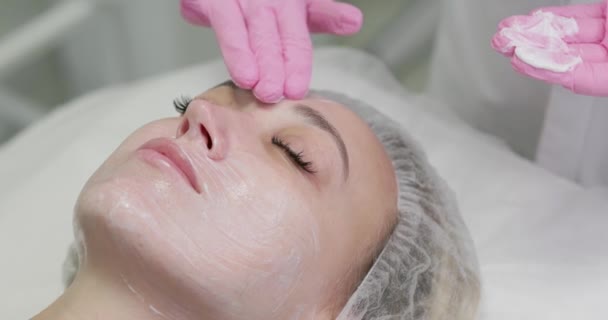 Kosmetolog Nakłada Odżywczą Maskę Młodą Kobietę Salonie Spa Zbliżenie Kobiety — Wideo stockowe