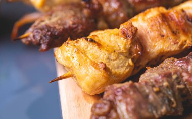 Brazilian churrasquinho. Kebabs with beef and chicken meat and bacon, known in Brazil by the name of churrasquinho. Wooden board, farofa and vinaigrette in the composition. Above view.