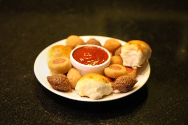 Makro shot 'lı ketçaplı sos tutacağı olan bir tabakta çeşitli Brezilya çerezleri. Siyah arkaplan.