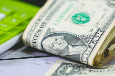 Para geçmişini dolar banknotları ve hesap makinesiyle kapatın. Ekonomi ve finans kavramı.