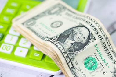 Para geçmişini dolar banknotları ve hesap makinesiyle kapatın. Ekonomi ve finans kavramı.