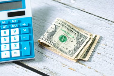 Para geçmişini dolar banknotları ve hesap makinesiyle kapatın. Ekonomi ve finans kavramı.