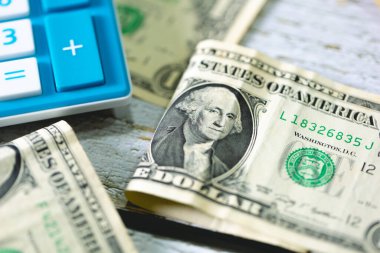 Para geçmişini dolar banknotları ve hesap makinesiyle kapatın. Ekonomi ve finans kavramı.