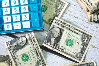 Para geçmişini dolar banknotları ve hesap makinesiyle kapatın. Ekonomi ve finans kavramı.