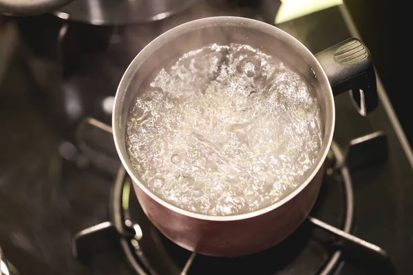 暗いストーブの上で米を調理するための水沸騰 — ストック写真