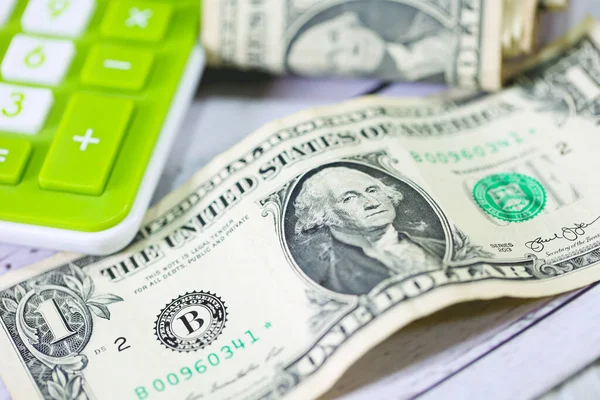 Para geçmişini dolar banknotları ve hesap makinesiyle kapatın. Ekonomi ve finans kavramı.