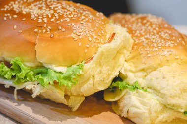 Susamlı sandviç, hindi göğsü, mozzarella peyniri, marul, domates ve baharatlı mayonez. 