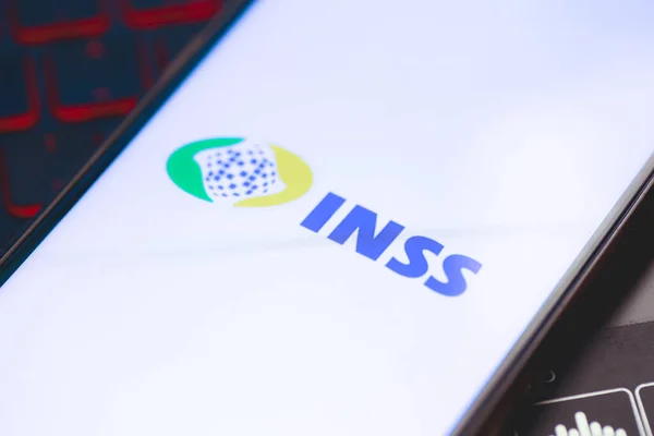 stock image Brasilia, Federal District, Brazil - April, 2023. Cell phone with the INSS logo on the screen. National Institute of Social Security in Brazilian Portuguese. 