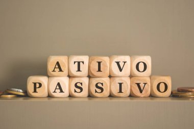 Brezilya Portekizcesi Active PASSIVE yazılı tahta küplere ve gri arka planda bozuk paralara. Stüdyo fotoğrafı. 