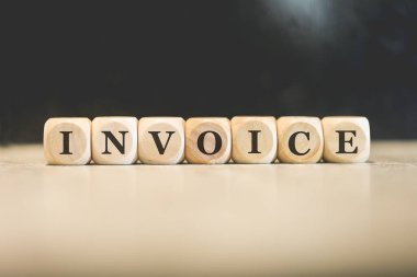 Tahta küplere yazılmış INVOICE yazıları. Siyah arkaplan. 