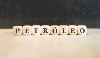 Portekizce PETROLEUM kelimesi tahta küplere yazılmış. Siyah arkaplan. 