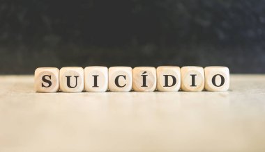 Brezilya Portekizcesi 'nde tahtadan küplere yazılmış intihar kelimesi. Siyah arkaplan. 